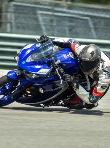 Person Riding Motorcycle with Impact Detect Integrated into Motorcycle Helmet