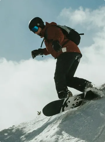 Person Riding Snowboard with Impact Detect Integrated into Extreme Sports Helmet