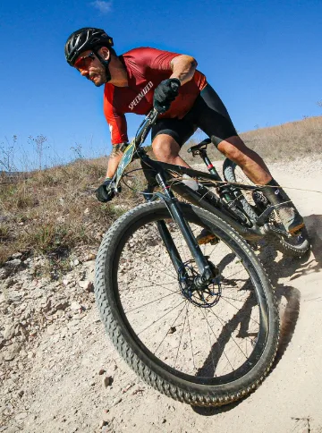 Person Riding Bicycle with Impact Detect Integrated into Cycling Helmet
